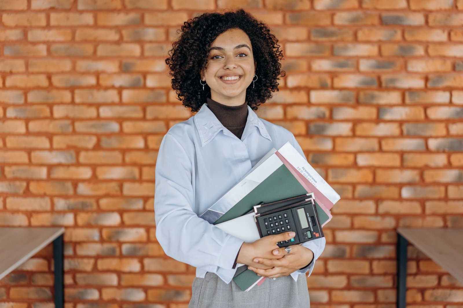 Smiling client holding folders and a calculator